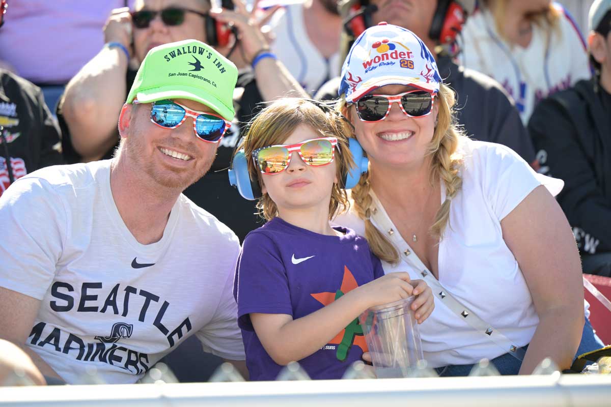 Mom and Dad enjoying a NASCAR race at Phoenix Raceway with their child